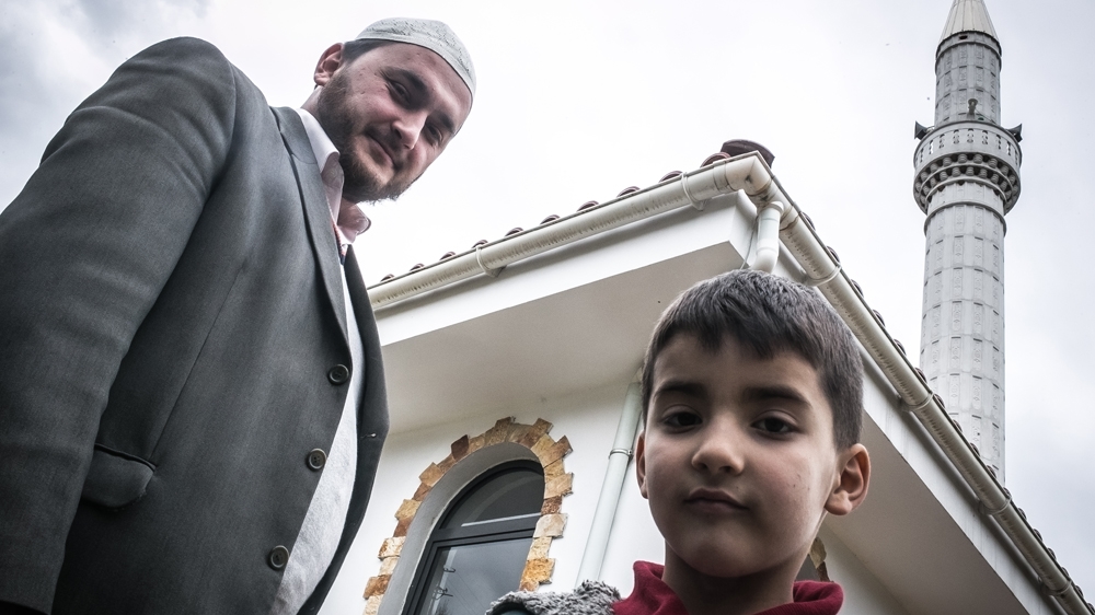 Imam Gentjan Mara and his son, in front of the mosque in the neighbourhood of Babrru, Tirana [Nicola Zolin/Al Jazeera] 