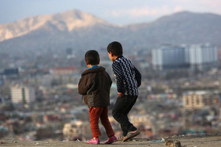 Afghan boys look at the view of Kabul city, Afghanistan [AP]