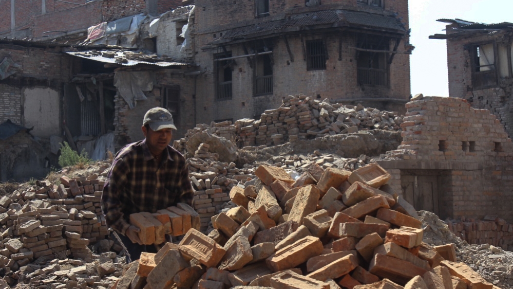 Residents of Bhaktapur, on the outskirts of Kathmandu, clear the rubble by hand [Saif Khalid/Al Jazeera]