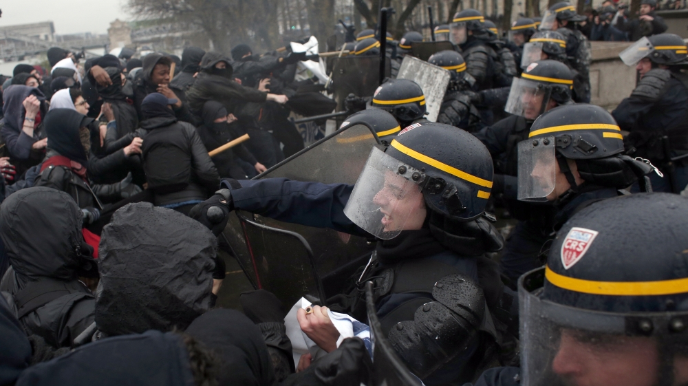 Youth clash with riot police in Paris during Thursday's protest [Thibault Camus/The Associated Press]