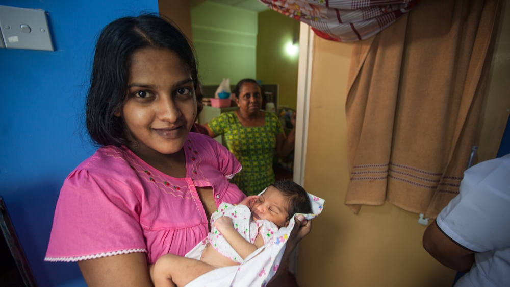 Shanthini Kumarasiri cradles her newborn son. In 1955, some 405 women died for every 100,000 live births. By 2013, that figure dropped to 32 [Suda Shanmugaraja/Al Jazeera]  