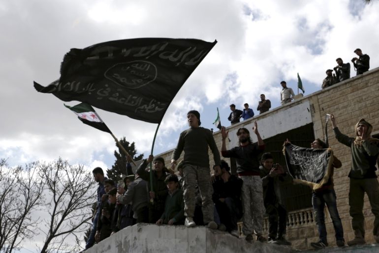 Protesters carry Al-Qaeda flags during an anti-government protest after Friday prayers in the town of Marat Numan in Idlib province