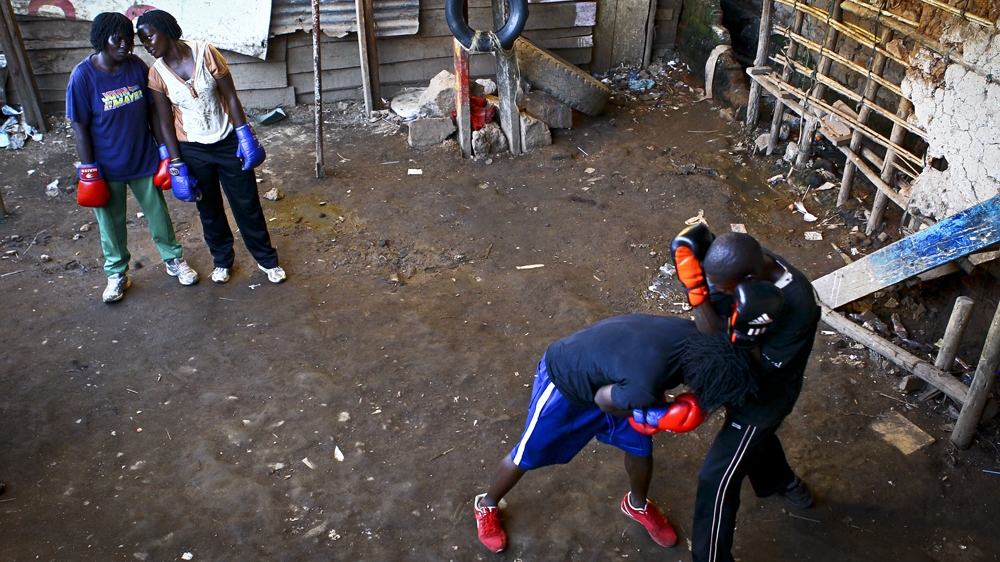 Morine Nakilyowa and Hellen Baleke watch their trainers box [Edward Echwalu/Al Jazeera] 