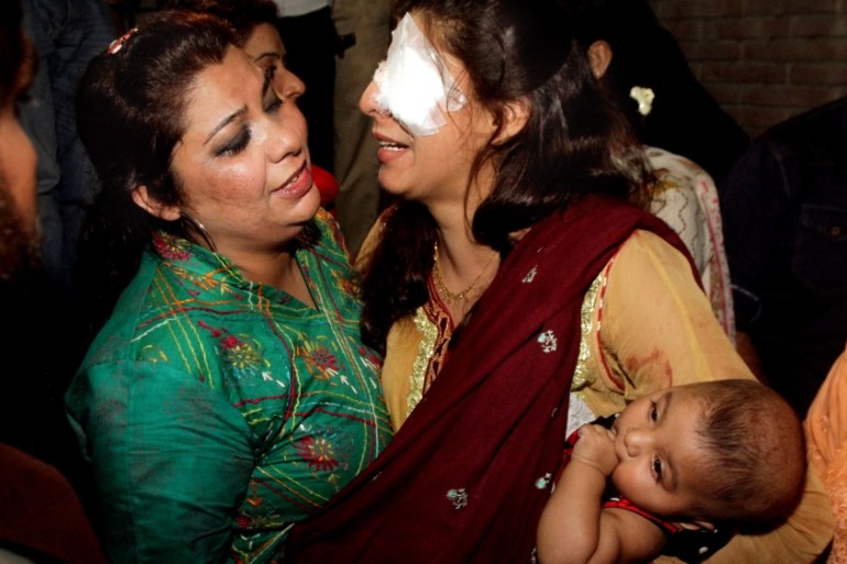 A woman injured in the bomb blast is comforted by a family member at a local hospital in Lahore, Pakistan [AP]