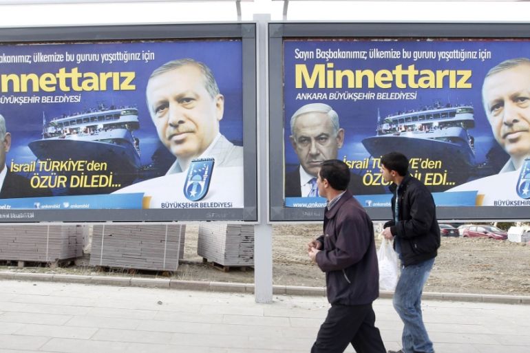 Pedestrians look at billboards with the pictures of Turkey''s Prime Minister Erdogan and his Israeli counterpart Netanyahu in Ankara