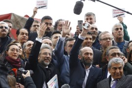 Can Dundar, editor-in-chief of Cumhuriyet, and his Ankara bureau chief Erdem Gul greet their supporters as they arrive at the Justice Palace in Istanbul