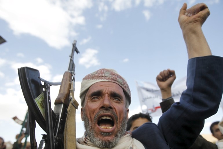 A follower of the Houthi shouts slogans as he raises his weapon in Yemen''s capital Sanaa