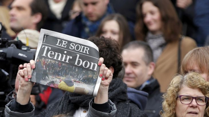 A newspaper is held up following a minute silence for victims of bomb attacks in Brussels, Belgium