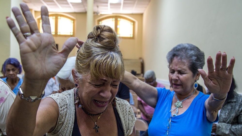 A prayer service reaches a crescendo at the First Baptist Church in Old Havana. The women ask God to save the 'lost youth' of Cuba   [Tomas Ayuso/Al Jazeera] 