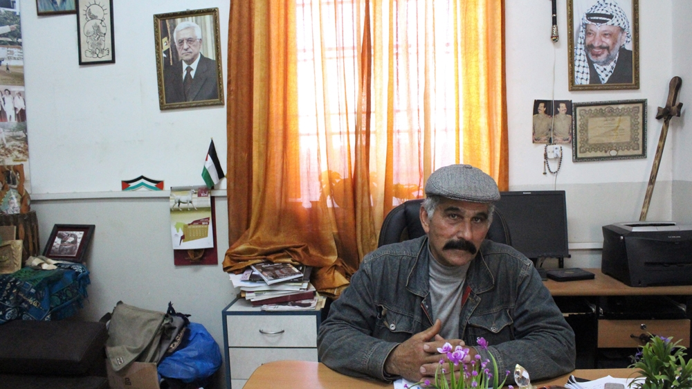 Nabil Samara sits at his principal's desk in Beitunya boys' high school. Samara resigned from the teachers' union in February. [Mary Pelletier/Al Jazeera]