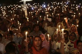 Pakistani Christians hold candles during a vigil for victims of a deadly suicide bombing in Lahore, Pakistan [AP]