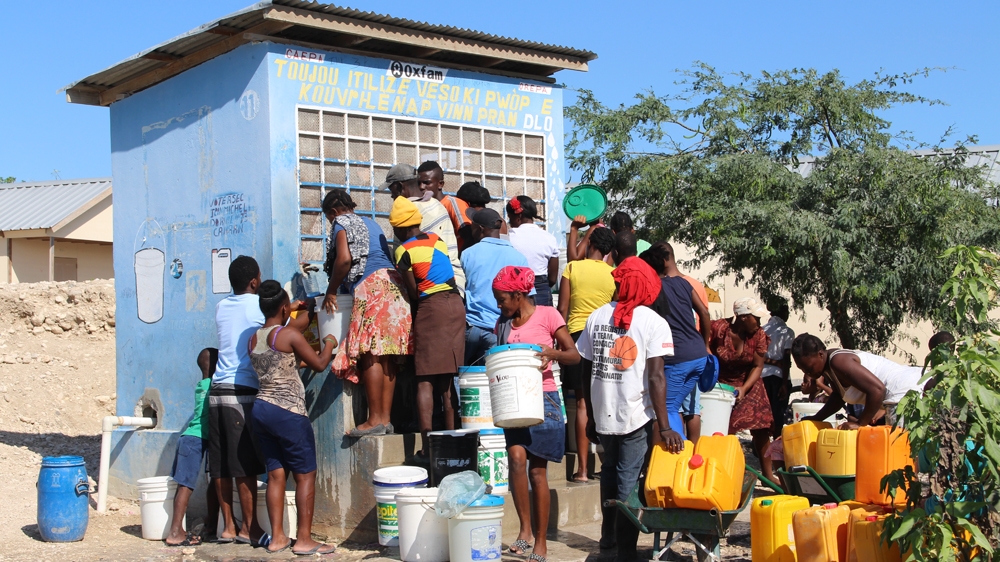 Most of Canaan's residents have to go to water kiosks several times a day to fill up canisters to cook, wash, do laundry and water plants [Stephanie Ott/Al Jazeera] 