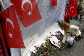 A woman places carnations and a candle at the scene of a suicide bombing at Istiklal street, a major shopping and tourist district, in central Istanbul