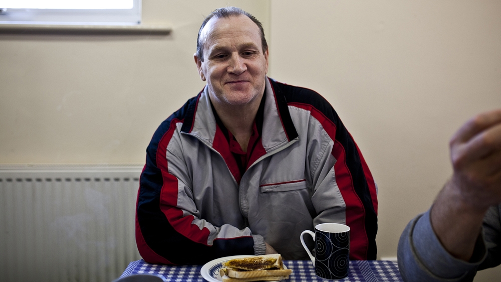 Stuart is one of the Chadderton Community Church foodbank's regular users. 'I basically use the service to help me get through the week. It's nice to have a chat, some coffee and toast.' Stuart lives on a local estate and used to be a furniture fitter. He has now been unemployed for seven years owing to ill health and misses his work. Many in similar situations talk about loneliness. They say it is nice to come to such places to socialise, 'instead of watching TV on your own all day' [David Shaw/Al Jazeera]