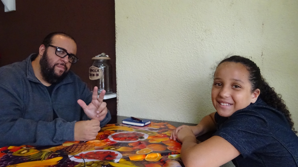 Ferrez and his daughter at lunch in Capao Redondo [Kathleen McCaul/Al Jazeera]