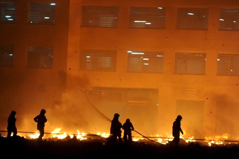 Firefighters participate in efforts to put out a fire that broke out at a residential tower in Ajman
