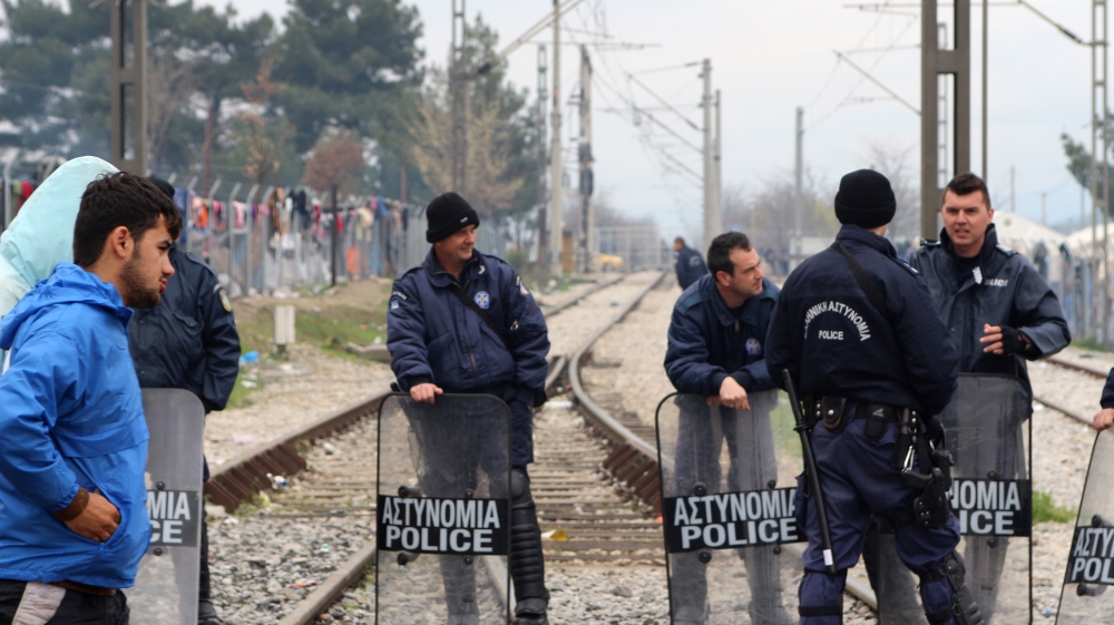 A line of Greek police prevent refugees from approaching the border fence [John Psaropoulos/Al Jazeera]