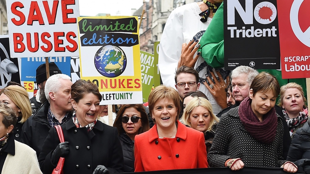 Scottish First Minister Nicola Sturgeon, in red, joins anti-Trident demonstrators on a march organised by the Campaign for Nuclear Disarmament entitled 'Stop Trident' in London [Andy Rain/EPA]