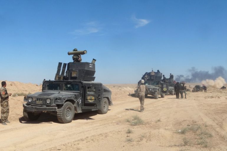 Iraqi security forces vehicles move toward the town of Hit during a military operation, in west of Ramadi