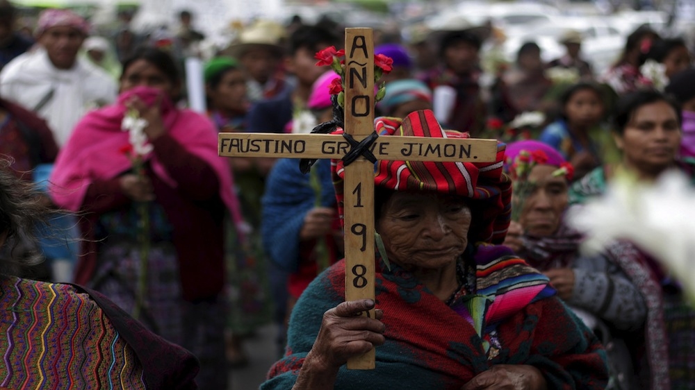 An indigenous woman holds a cross during a march to commemorate the National Day of Dignity for the Victims of Armed Internal Conflict [REUTERS/Josue Decavele]