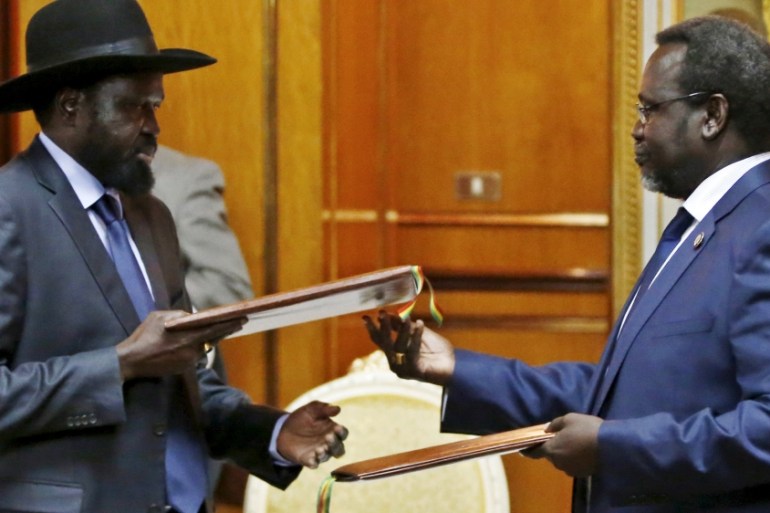 File photo shows South Sudan''s rebel leader Riek Machar and South Sudan''s President Salva Kiir exchanging signed peace agreement documents in Addis Ababa