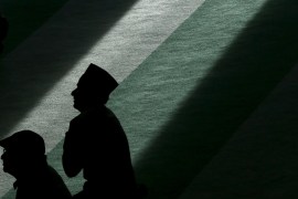 Muslim men listen during the Friday prayer at the Baitul Futuh Mosque in Morden