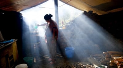 A woman boils water at a temporary shelter in Dhunche, Rasuwa District, Nepal [EPA]