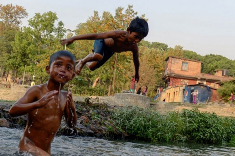 Nepalese boys swim in a river as they beat the summer heat in Kathmandu on April 22, 2016. PRAKASH MATHEMA / AFP