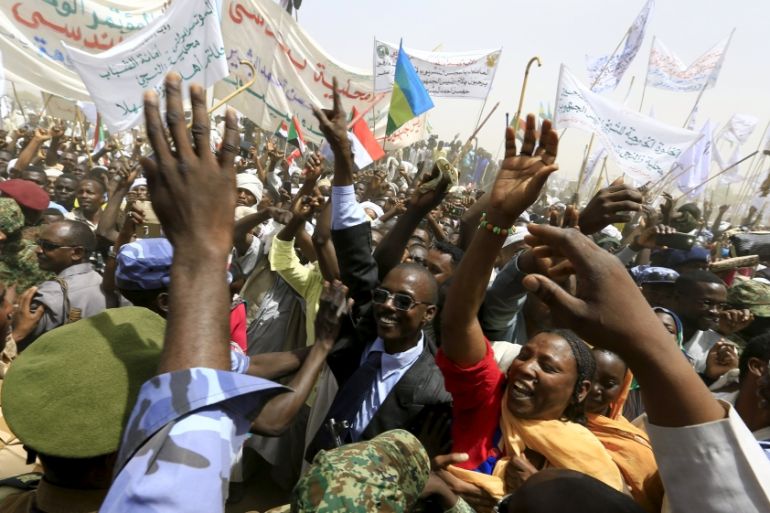 Supporters wave as Sudanese President Omar Hassan al-Bashir addresses the crowd during a peace campaign rally in Zalingei airport in Darfur