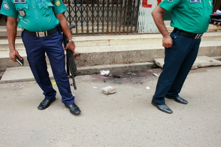 Bangladeshi police officers investigate at the site where unknown assailants hacked student activist Nazimuddin Samad,