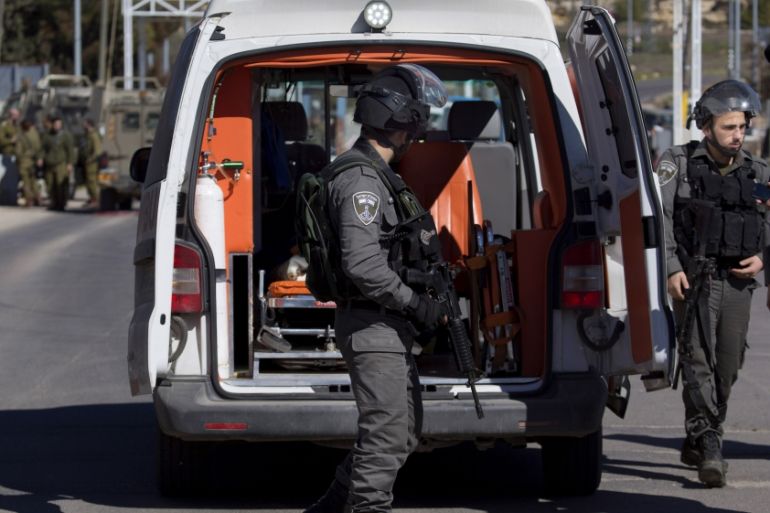 Israeli security forces inspect a Palestinian ambulance arriving