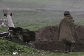 Armenian soldier of self-defense army of Nagorno-Karabakh stands near artillery unit in Martakert where clashes with Azeri forces are taking place in Nagorno-Karabakh region