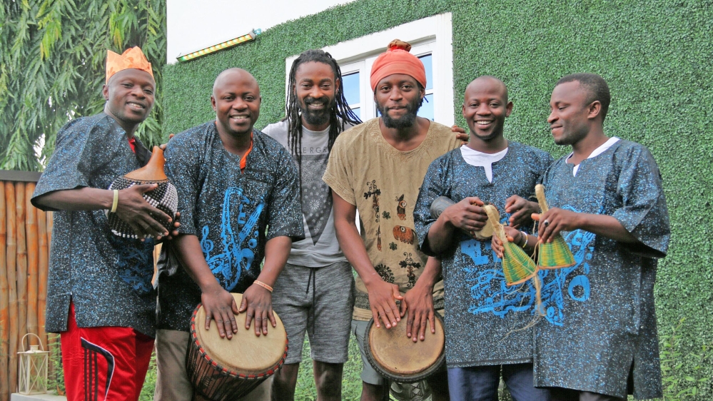 A band beats African drums and other instruments, producing fast-paced, upbeat music to which people exercise [Constance C Ikokwu/Al Jazeera]