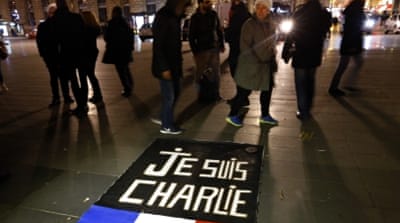 People walk around a banner reading 'Je suis Charlie' on the Place de la Republique in Paris, France [AP]