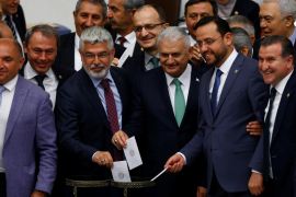 Binali Yildirim, the likely new leader of Turkey''s ruling AK Party, poses with MPs as he votes during a debate at the Turkish parliament in Ankara