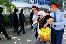 Riot police officers detain demonstrators during protest against President Nazarbayev''s government in Almaty