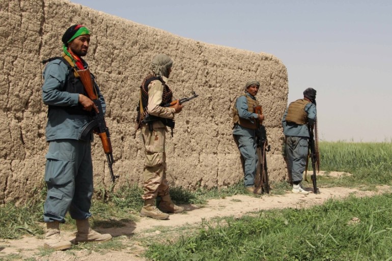 Afghan policemen keep watch during a battle with the Taliban in Nahr-e Saraj district of Helmand province, Afghanistan