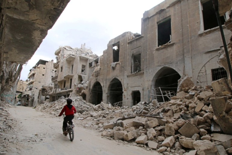 A boy rides a bicycle near damaged buildings in the rebel held area of Old Aleppo, Syria [REUTERS]