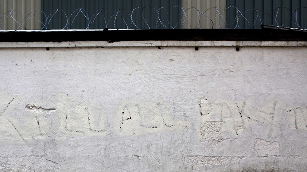 Racist graffiti has been partially scrubbed from a wall in the town  [David Shaw/Al Jazeera]