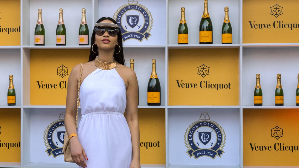 A spectator poses at a champagne merchandise stand at the 2016 Lagos International Polo Tournament [Andrew Esiebo/Al Jazeera] 