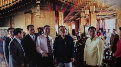 Kings Romans Group chairman Zhao Wei, centre left, in white shirt, with former Laotian President Choummaly Sayason, centre right, in a promotional brochure for the Kings Romans Casino [Sebastian Strangio/Al Jazeera]