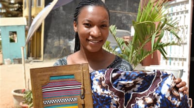 American tourist Carmen Paraison poses with some of her purchases during her holiday in Dakar [Kait Bolongaro/Al Jazeera]