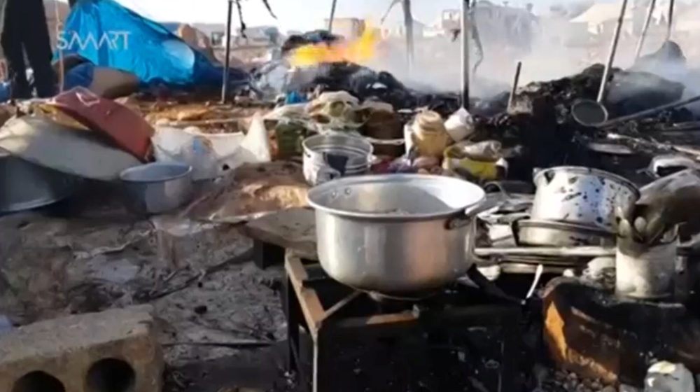 Cooking utensils are seen in burnt tents at a camp for internally displaced people near Sarmada in Idlib province [Reuters]