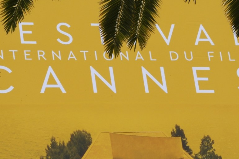 Palm fronds frame a giant canvas of the official poster of the 69th Cannes Film Festival in Cannes, France [REUTERS]