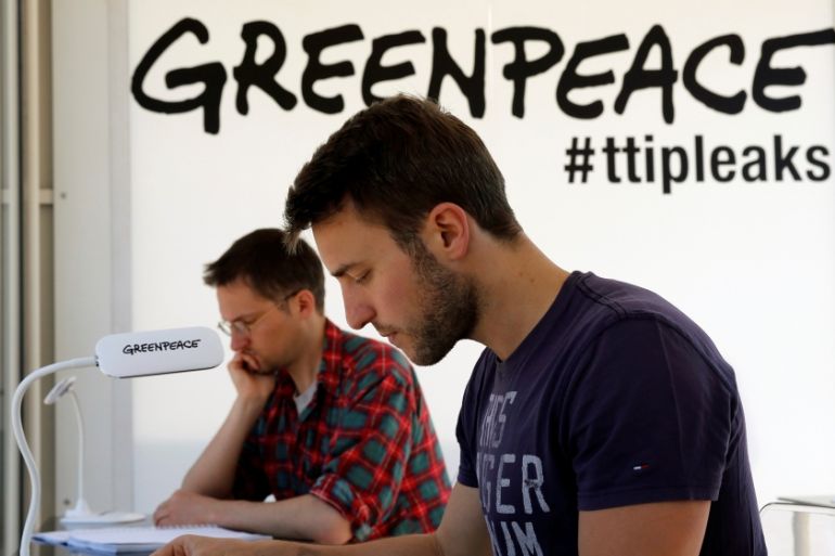 People read copies of the leaked TTIP negotiations inside a public reading room by the environmental campaign group Greenpeace in front of the Brandenburg Gate in Berlin