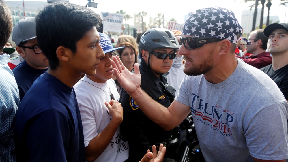 An anti-Trump demonstrator (L) and a Trump supporter (R) argue outside a campaign event [Jonathan Alcorn/Reuters]
