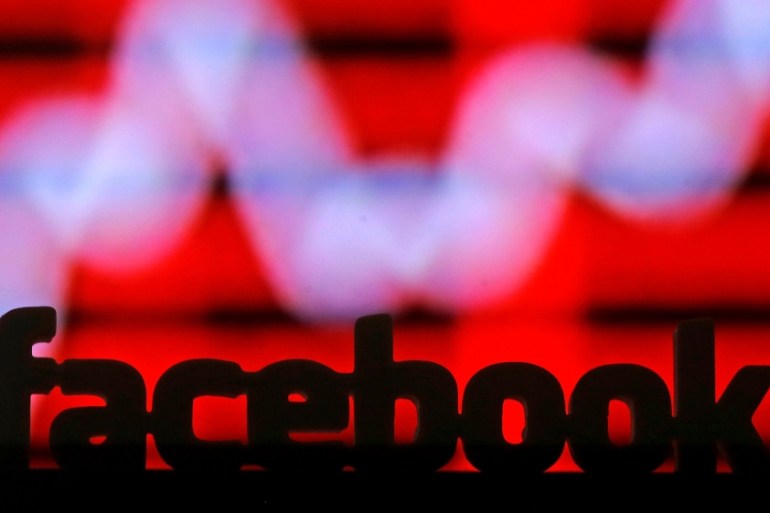 A 3D printed Facebook logo is seen in front of a displayed stock graph in this illustration taken