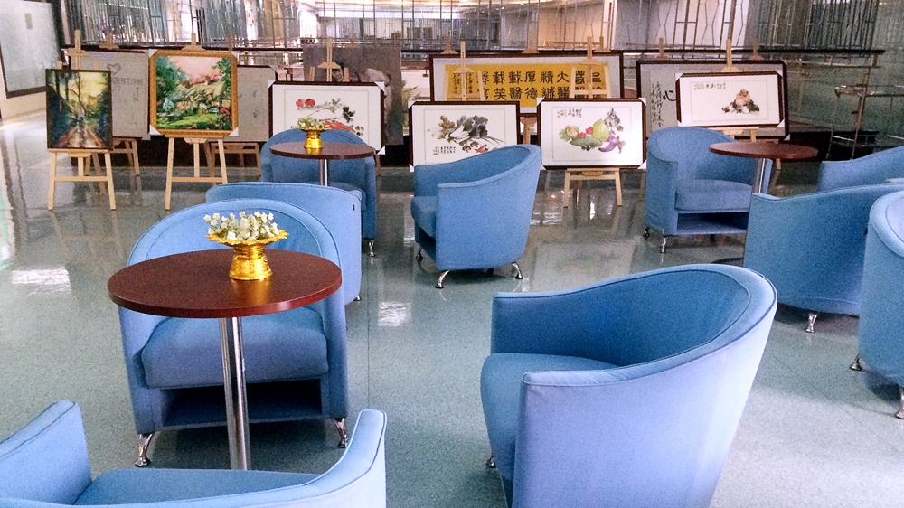 A common area in Fuda Cancer Hospital's patient ward is decorated with paintings sent by former patients [Simina Mistreanu/Al Jazeera]