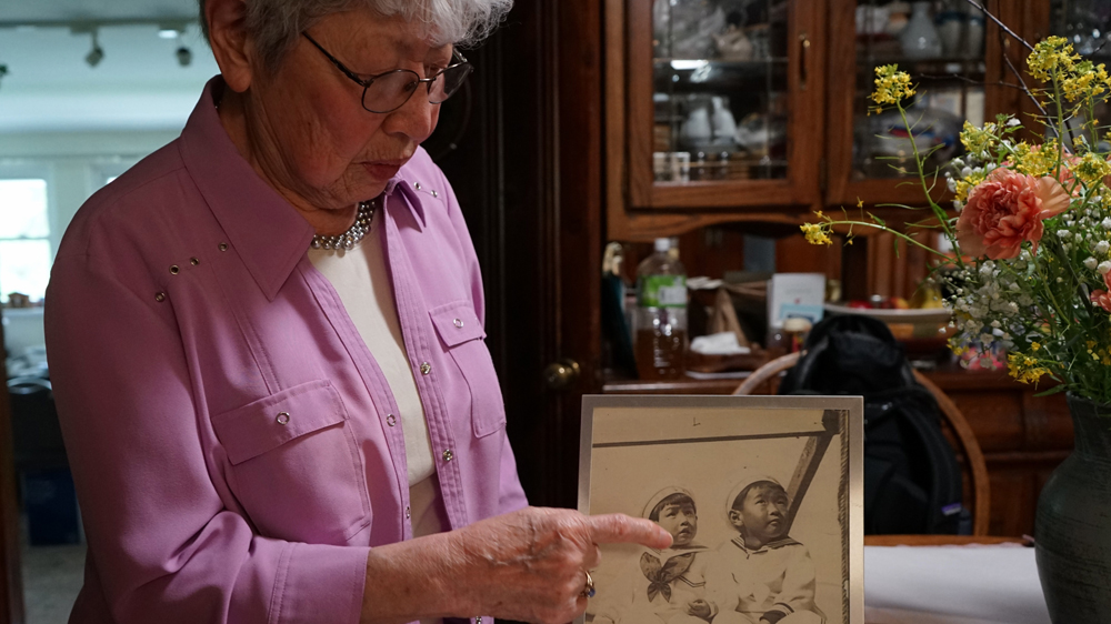Tomiko Morimoto West, 84, with a photograph from her childhood in Hiroshima [James Reinl/Al Jazeera]