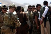 Soldiers from the US-led coalition, left, are seen with Kurdish Peshmerga forces in a village east of Mosul, Iraq, May 29 [Reuters]